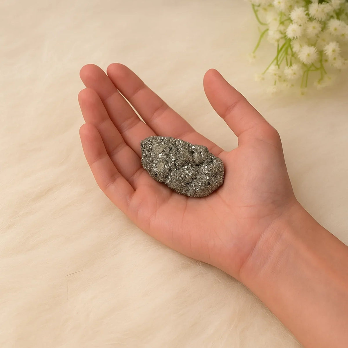 VASTUKOSHA raw pyrite stone with metallic luster held in a palm for prosperity-oriented spiritual practice