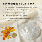 VASTUKOSHA raw selenite charging plate with white crystal shards, marigold petals, and a coin on a silk fabric background
