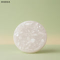 VASTUKOSHA raw white Moroccan selenite crystal plate for meditation and crystal cleansing on a soft green background