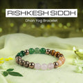 VASTUKOSHA Rishikesh Siddh Dhan Yog crystal bracelet featuring green, brown, and pink beads on a light fabric surface.