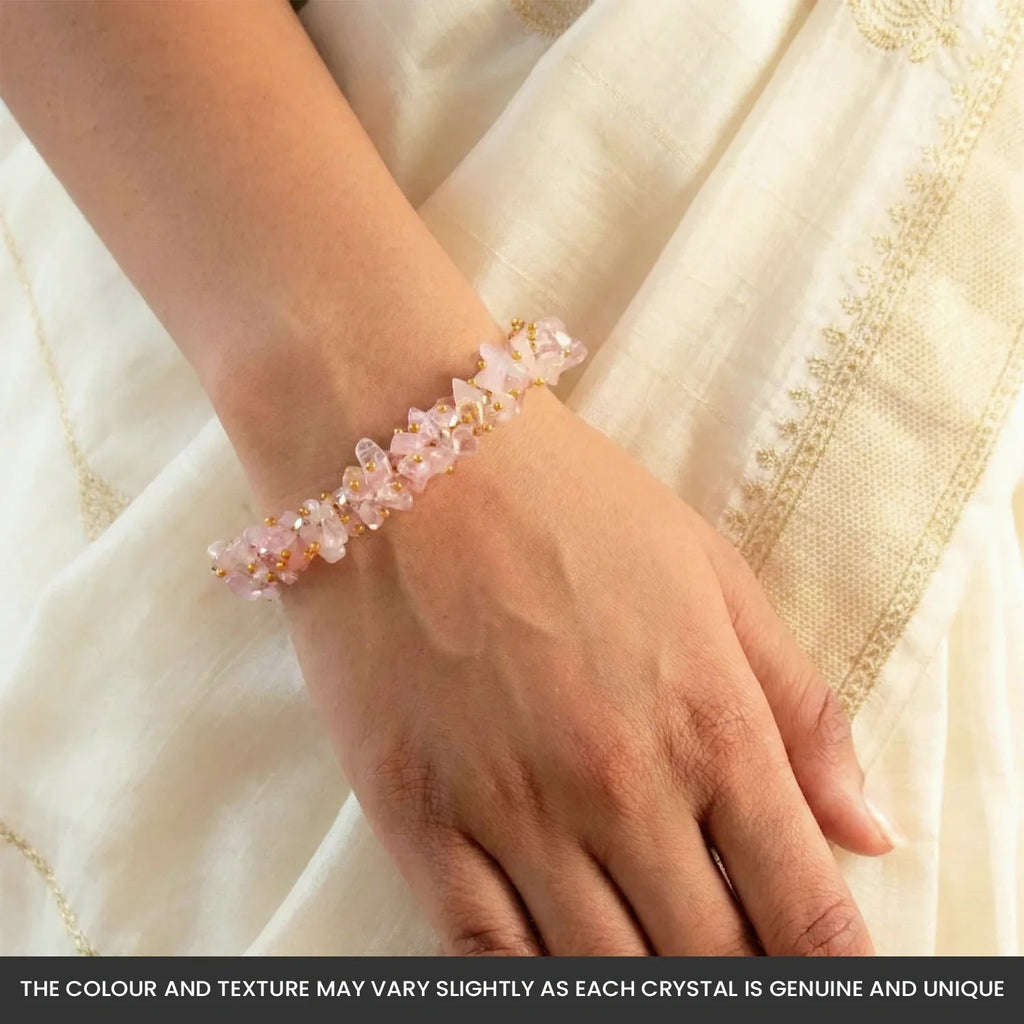 VASTUKOSHA rose quartz chip bracelet worn on a woman's wrist against a cream-colored fabric background