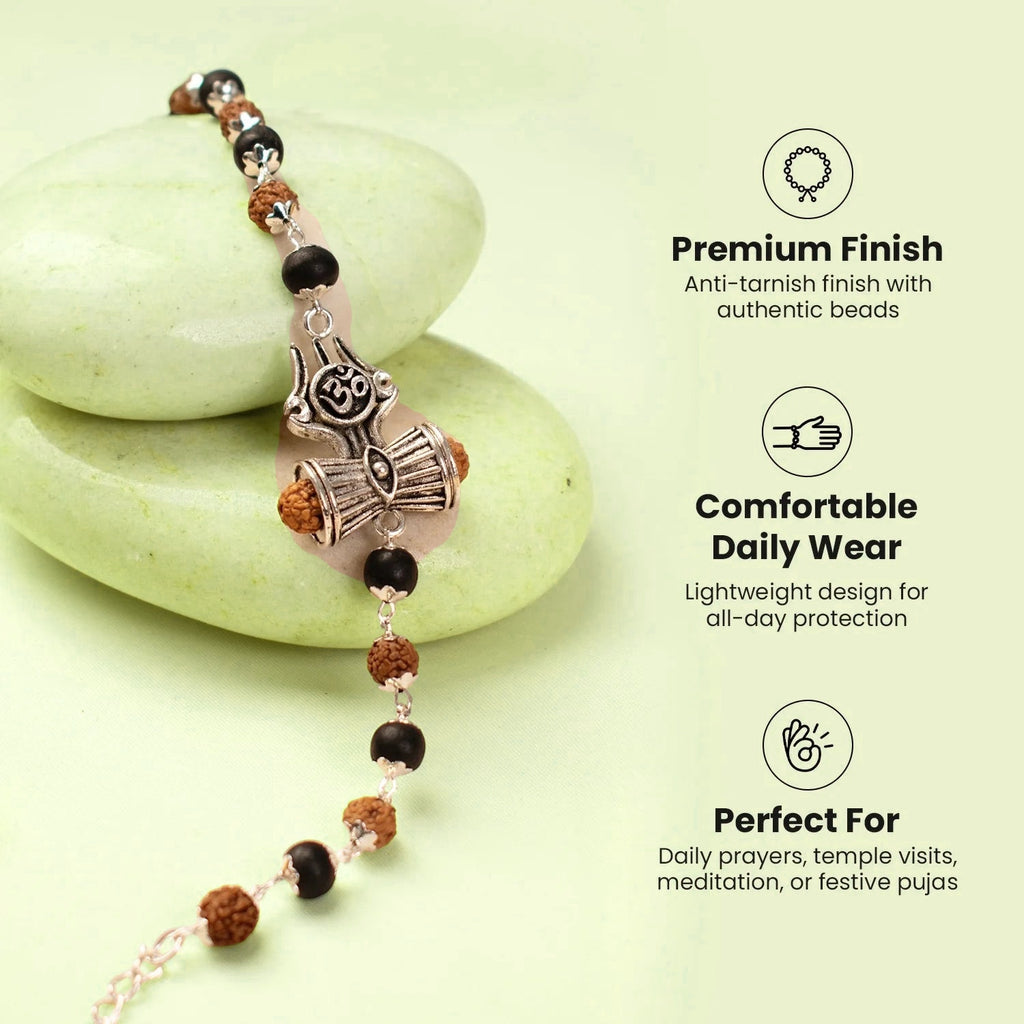 VASTUKOSHA Rudraksha and Karungali bead bracelet featuring a silver Om, Trishul, and Damru charm on a stone surface.