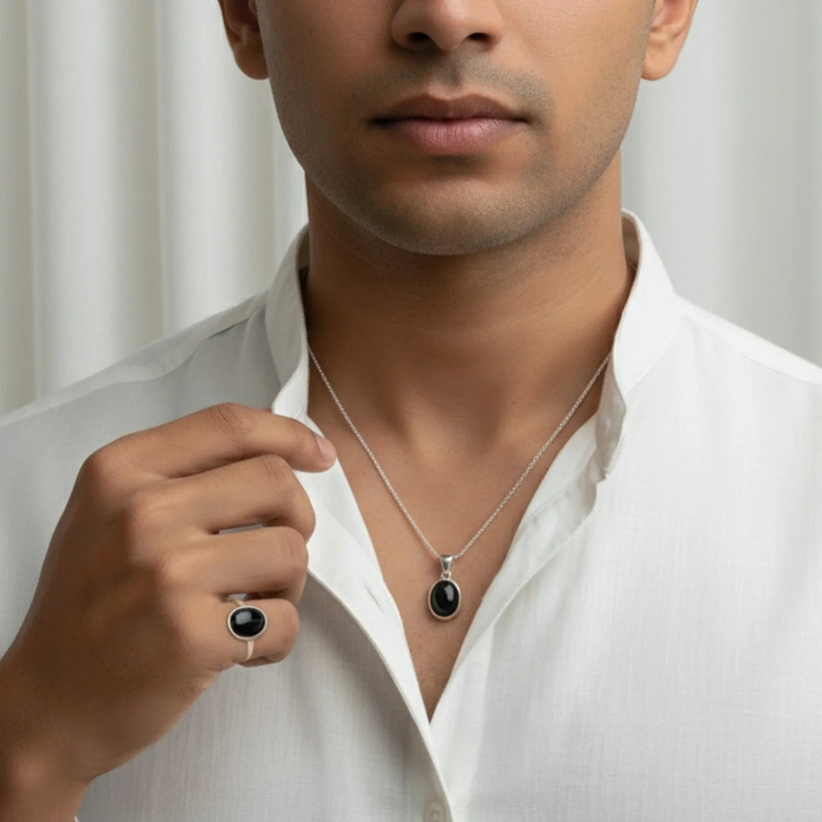 VASTUKOSHA Sulemani Hakik black agate pendant and ring set worn by a man in a white shirt for spiritual practice