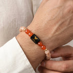 VASTUKOSHA Taurus zodiac bracelet featuring sunstone and carnelian beads with a black bull symbol charm on a wrist