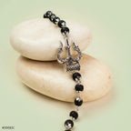 VASTUKOSHA Mahadev Trishul and Damru bracelet featuring black Karungali beads and oxidised silver metal accents.
