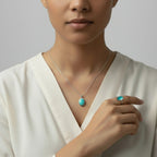 VASTUKOSHA turquoise gemstone pendant necklace and matching ring worn by a woman in a white top