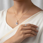 VASTUKOSHA White Pukhraj gemstone pendant and ring set in gold, worn by a woman in a white outfit.